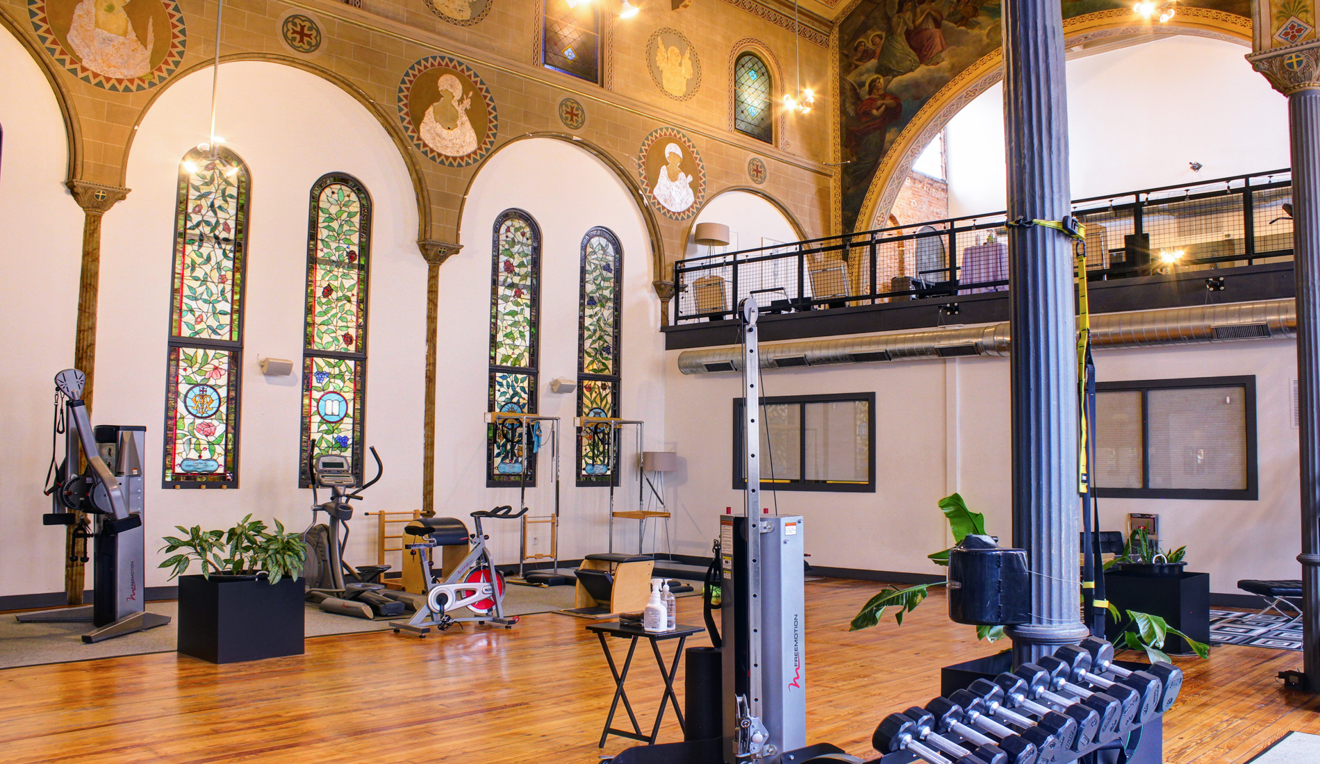 The Sanctuary Body studio - fitness equipment amidst stained glass and murals