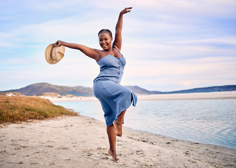 A curvy, healthy, happy woman radiates at the beach.